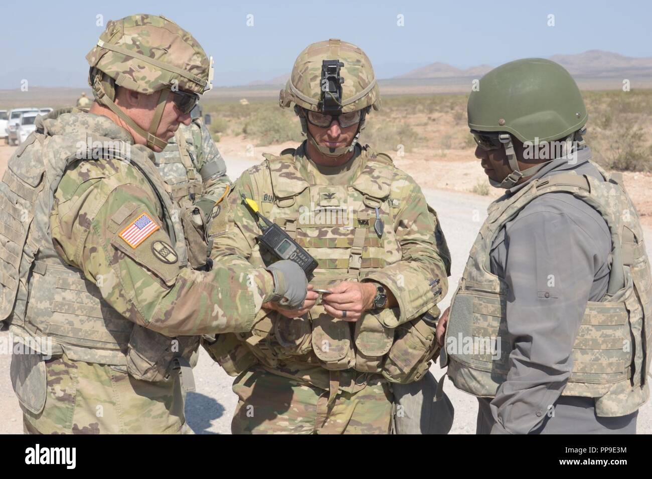 North Carolina National Guard Il Mag. Gen. Gregorio Lusk, aiutante generale del North Carolina National Guard, Col. Robert Bumgardner, comandante del trentesimo Armored Brigade Combat Team e Erik A. ganci, Segretario della Carolina del Nord del dipartimento della Pubblica Sicurezza visualizza una moneta durante il funzionamento Hickory Sting a Ft. Bliss, Texas, 14 agosto 2018. Funzionamento Hickory pungiglione è un combattimento esportabile capacità di formazione programma che sfida e preparare i soldati attraverso tutte le abilità speciali per essere più letale, efficace e tatticamente abili nel lavoro. (North Carolina National Guard Foto Stock