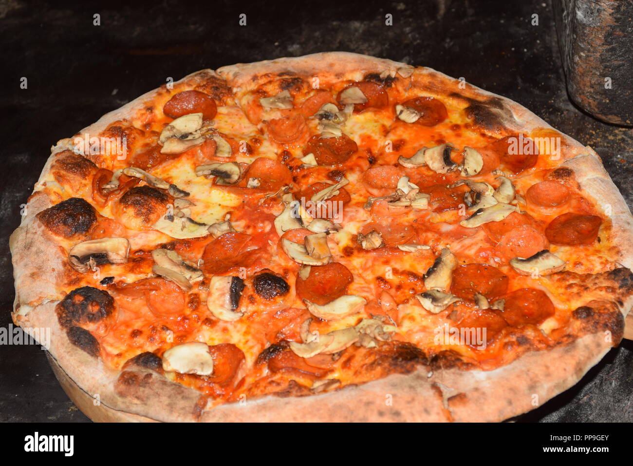 Freschi e originali della pizza italiana viene preparato e cotto in un tradizionale italiani di legno pietra fuoco forno di mattoni ho un ristorante a Baguio City, Filippine Foto Stock