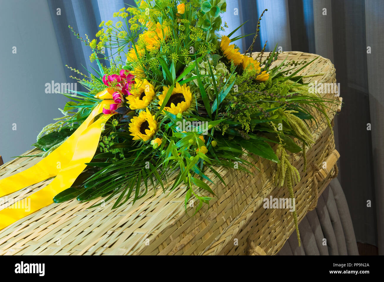 Un omaggio floreale in una bara intrecciato in una camera mortuaria Foto Stock