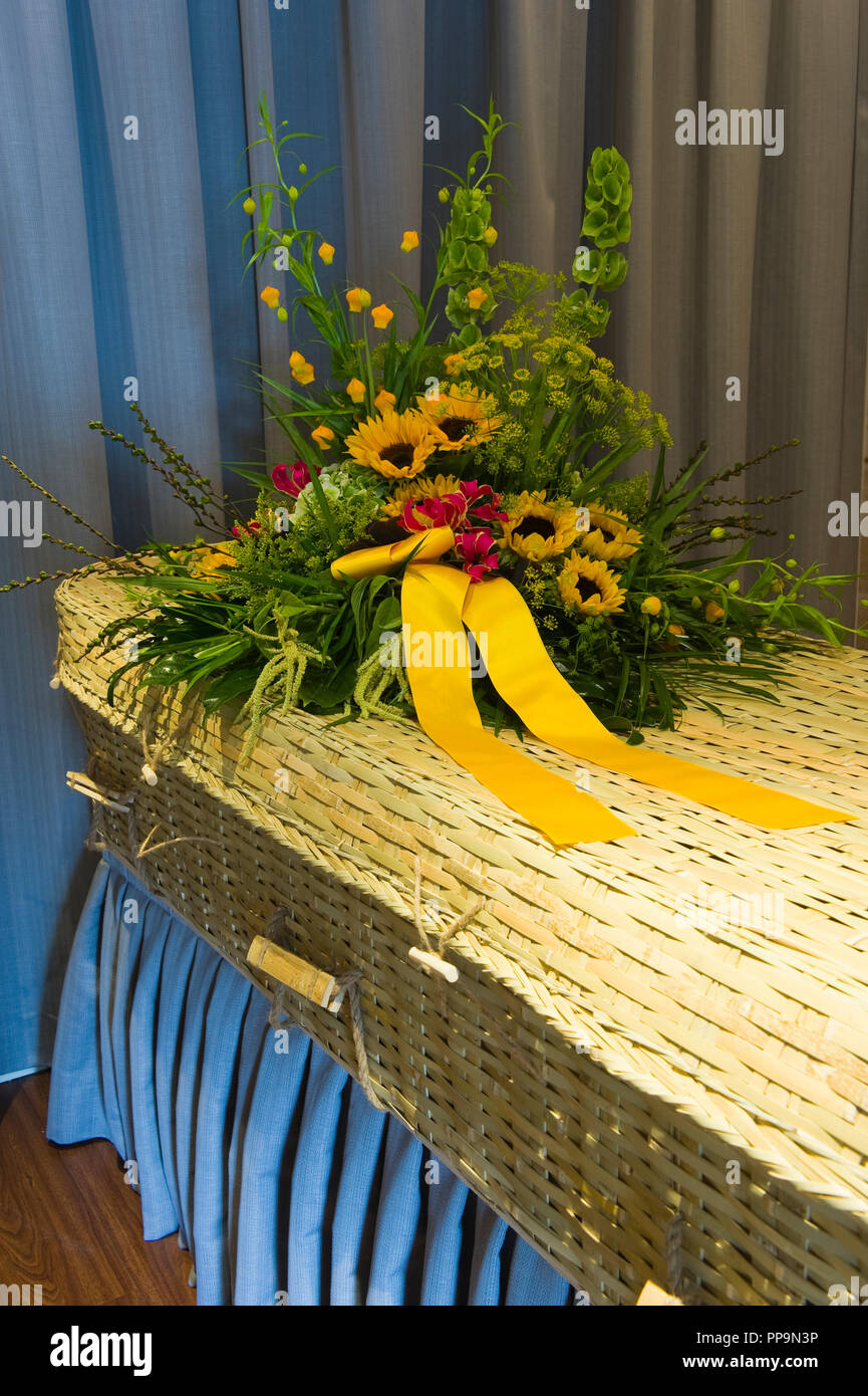 Un omaggio floreale in una bara intrecciato in una camera mortuaria Foto Stock