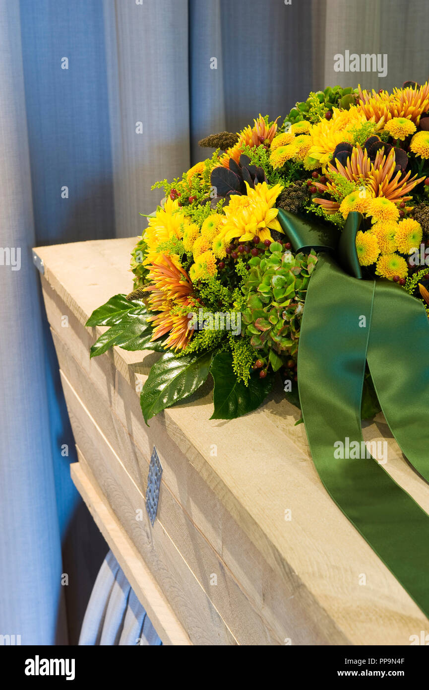Un omaggio floreale in una bara in una camera mortuaria Foto Stock