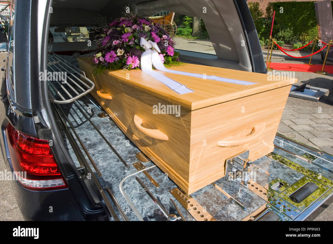 Una bara con un omaggio floreale in un funerale auto Foto Stock
