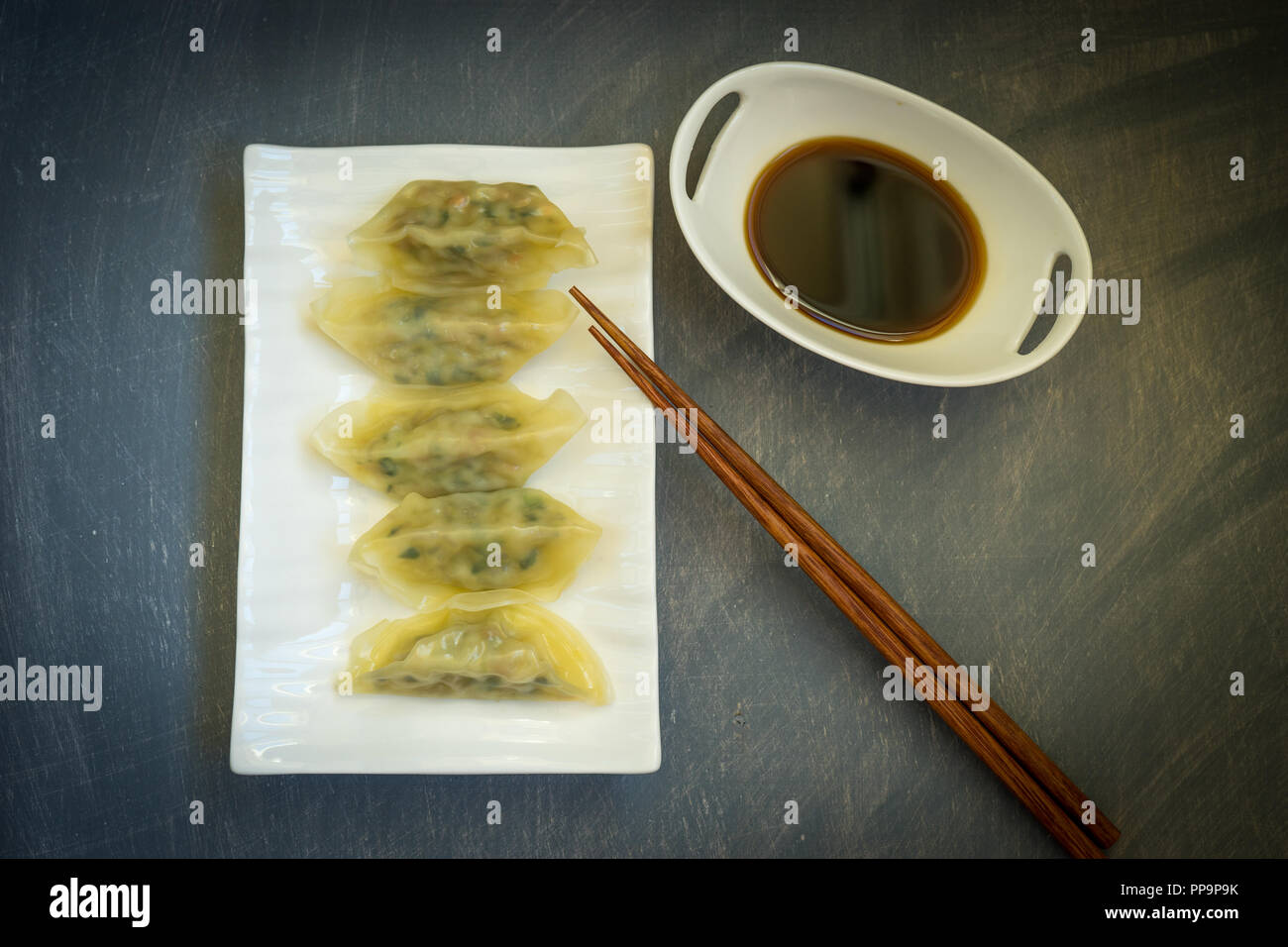 Gnocchi di asiatici in porcellana ware bianco su sfondo grigio. Foto Stock