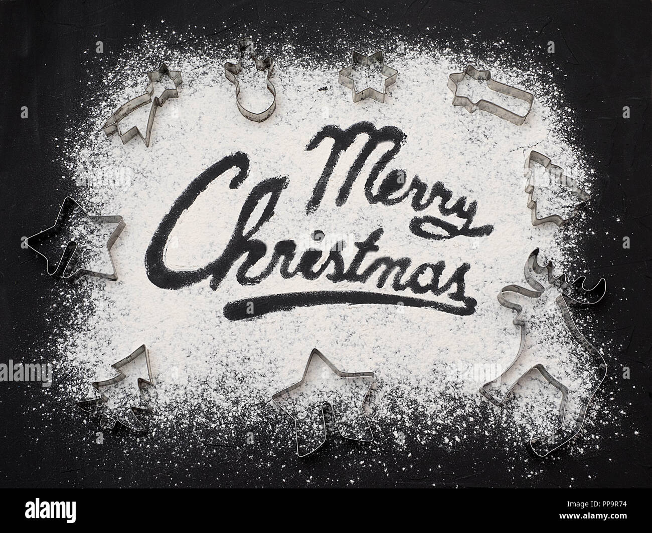 Auguri di Buon Natale parola scritta tavola nera. La cottura di natale. Rendendo pan di zenzero biscotti di Natale. Concetto di natale. Vista dall'alto. Copia dello spazio. Foto Stock