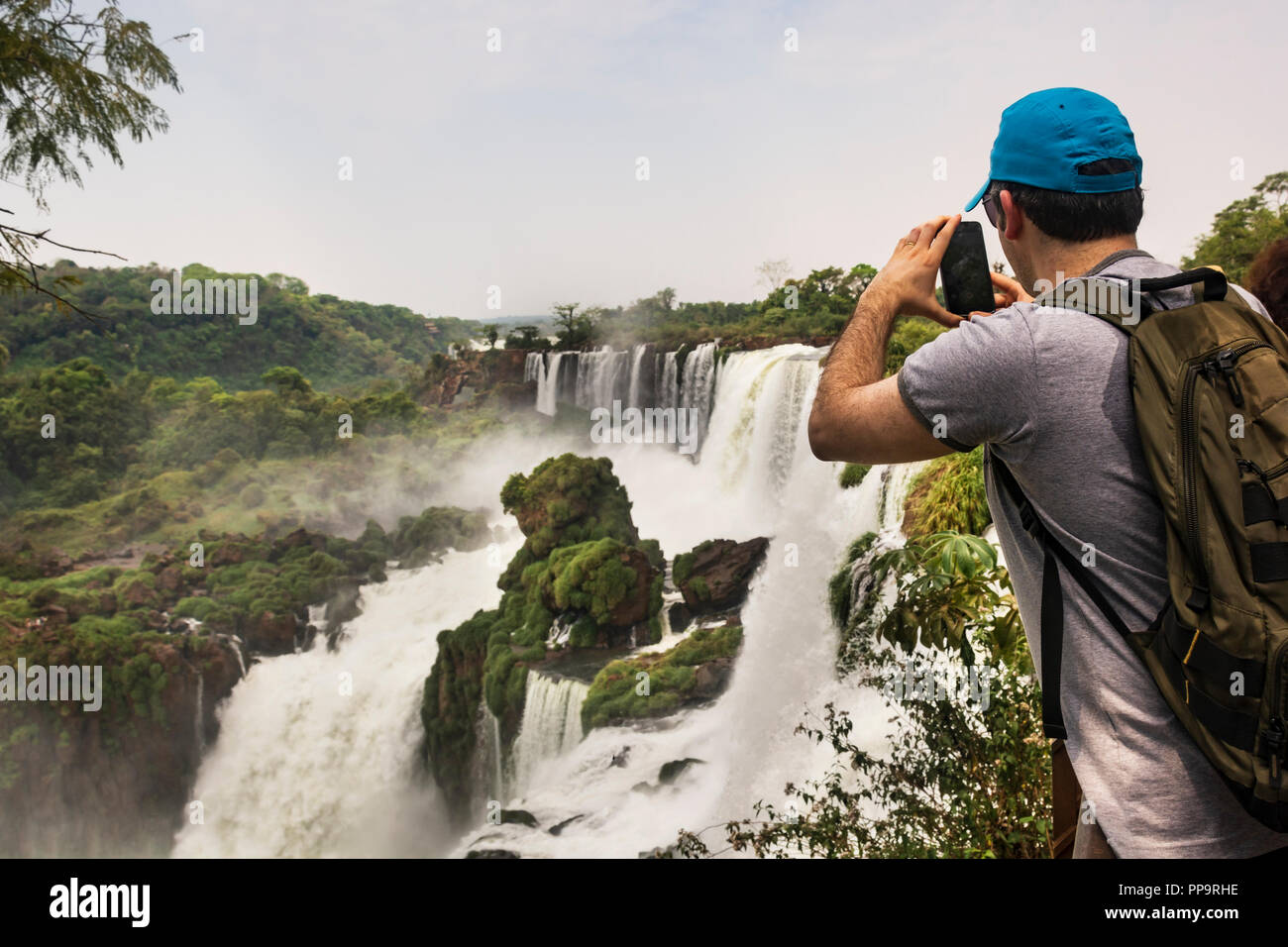 Parco Nazionale di Iguazu, Argentina. Un turista di scattare una foto delle Cascate di Iguassù con il suo telefono cellulare dotato di fotocamera digitale Foto Stock