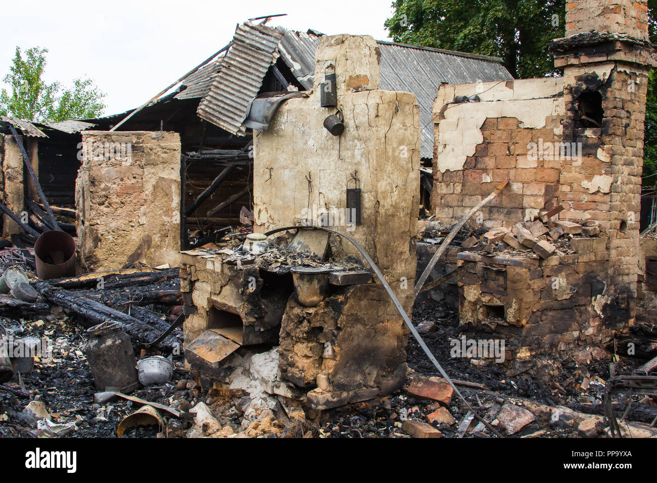 Stufa in una casa bruciata in una campagna, sullo sfondo di emergenza Foto Stock