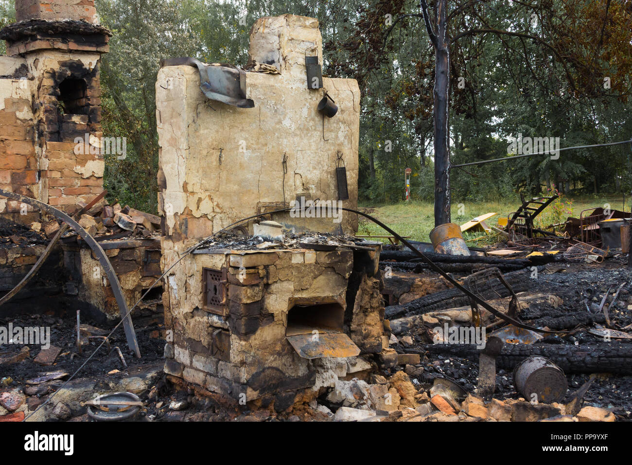 Stufa in una casa bruciata in una campagna, sullo sfondo di emergenza Foto Stock