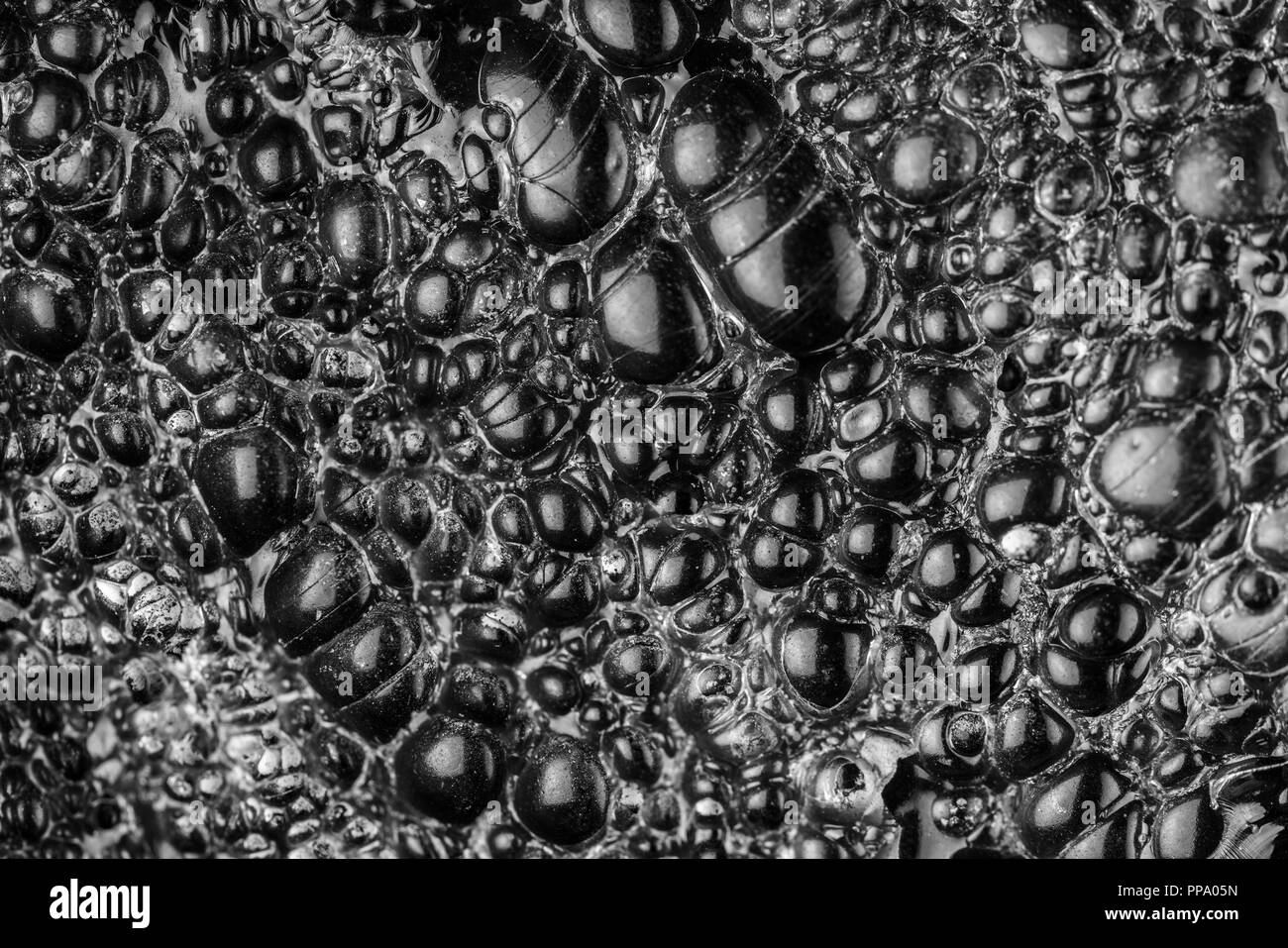 In prossimità della superficie di ossidiana o nero vetro vulcanico che mostra una superficie liscia coperto di bolle Foto Stock