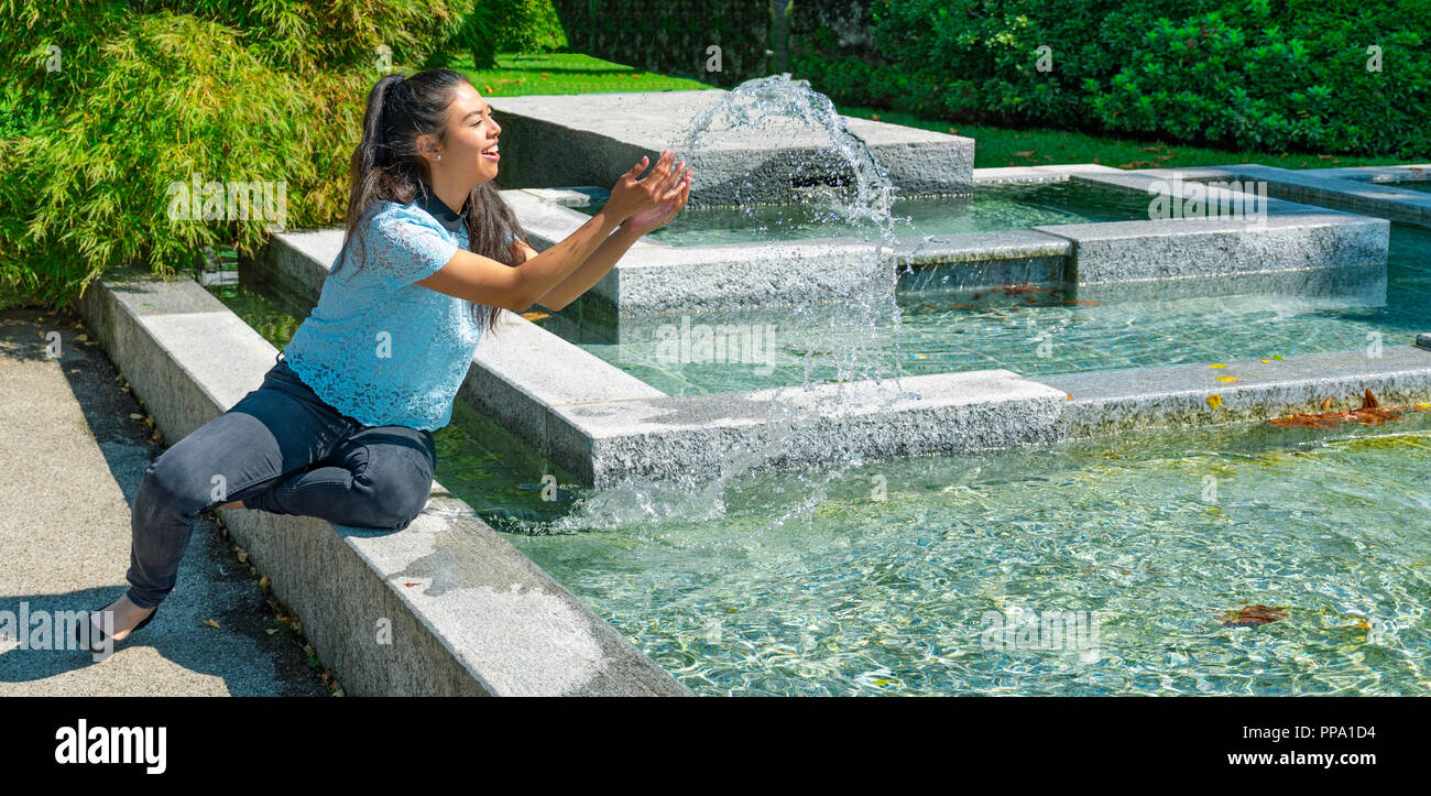 Ragazza che gioca con la fontana di acqua - Mädchen, das mit Brunnenwasser spielt - ragazza che gioca con l'acqua della fontana Foto Stock
