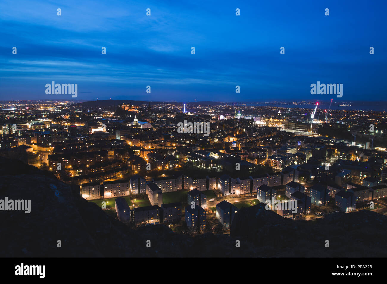 Edinburgh City skyline notturno con Salisbury Crags in primo piano, Scozia Foto Stock