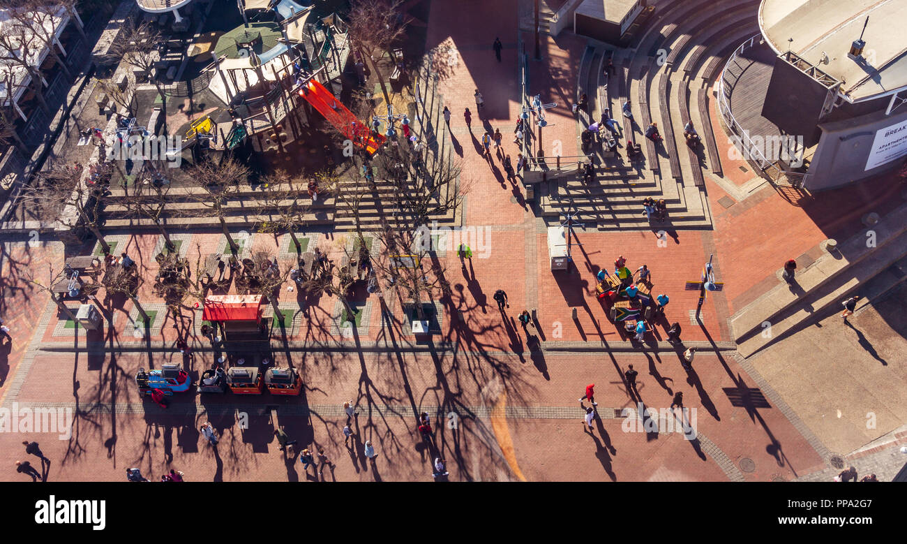 Le persone sono in movimento nel traino del capo, in Sud Africa, musicisti di strada la riproduzione di musica. Veduta aerea da Victoria & Alfred Waterfront. Foto Stock