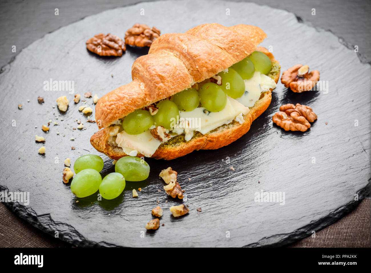 Croissant appena sfornati riempita con formaggio brie e uva Foto Stock