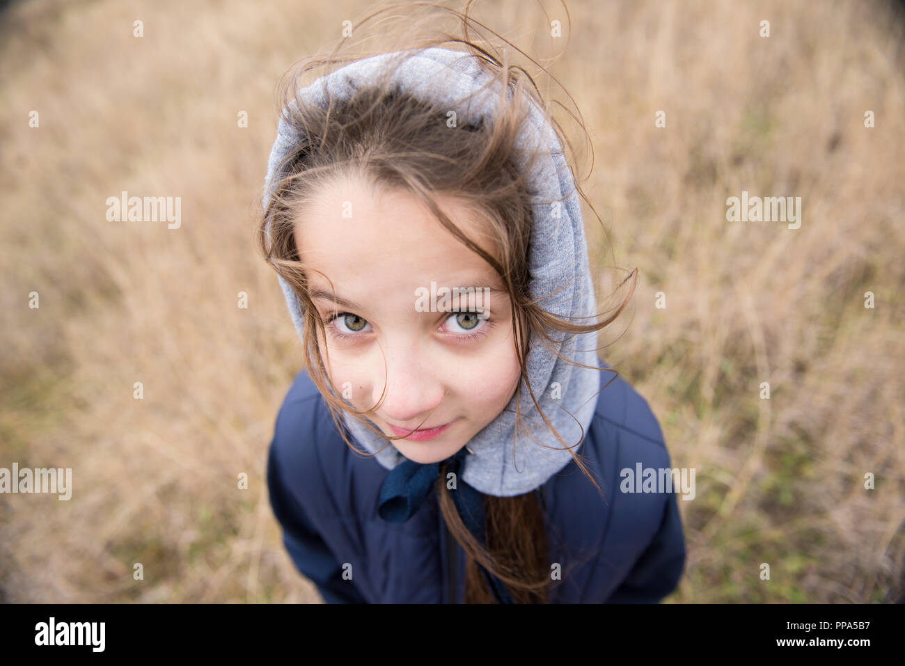 Primo piano della bella ragazza nel cofano e giacca con capelli vento meteo Foto Stock