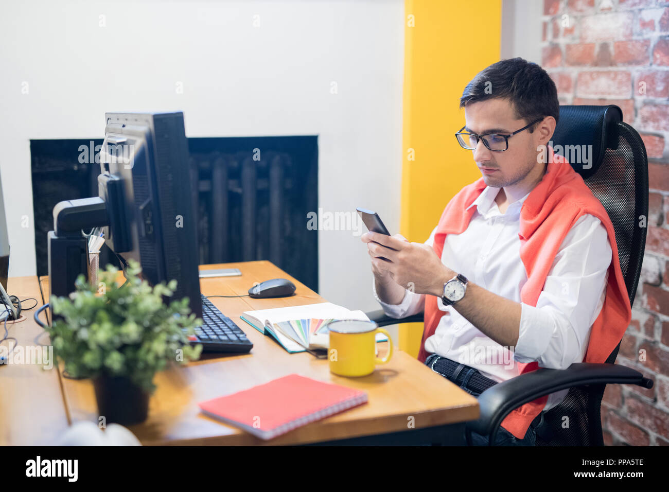 I giovani designer usando il telefono in ufficio Foto Stock