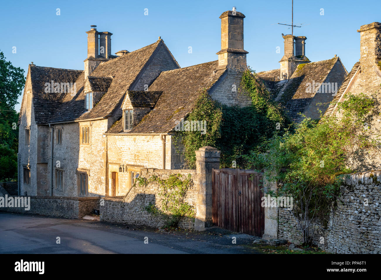 Case di villaggio Costwold di Coln St Dennis nella luce del sole della mattina, Cotswolds, Gloucestershire, Inghilterra Foto Stock
