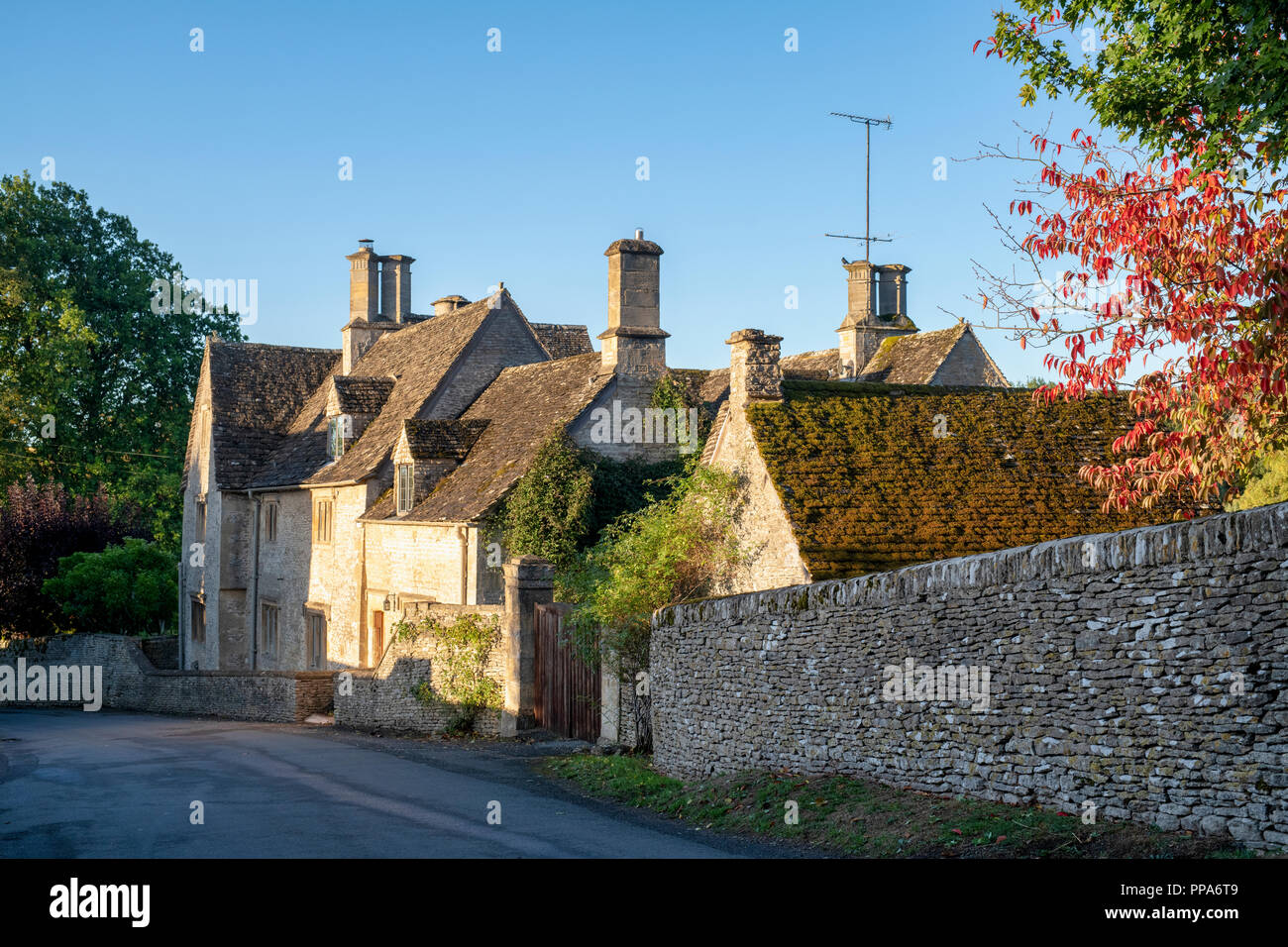 Case di villaggio Costwold di Coln St Dennis nella luce del sole della mattina, Cotswolds, Gloucestershire, Inghilterra Foto Stock