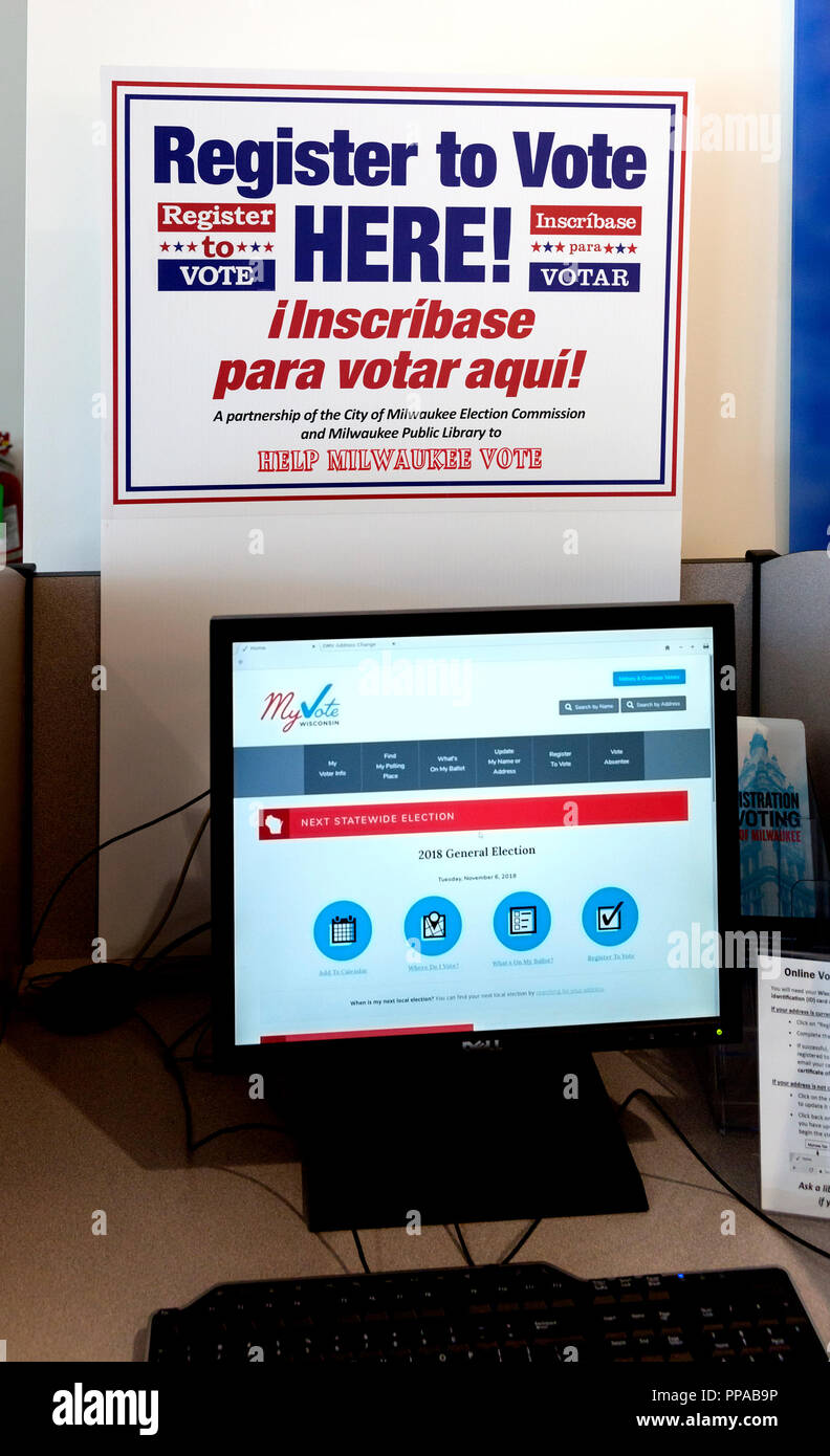 Stazione di computer e un cartello bilingue in inglese e in spagnolo di registro per il voto al Milwaukee Public Library, Wisconsin Foto Stock