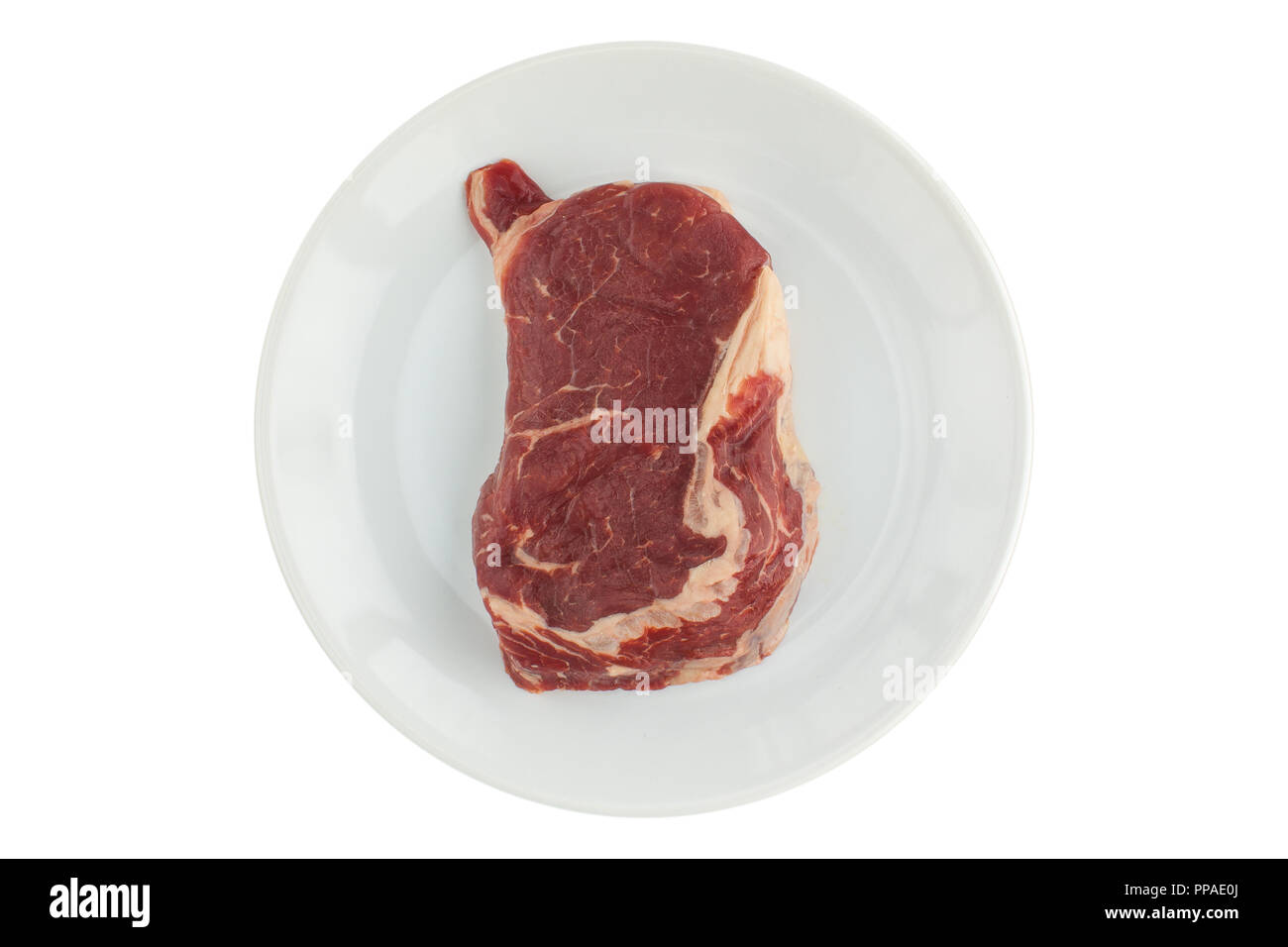 Un pezzo grezzo di carne (mature steak) su una piastra bianca su un sfondo isolato Foto Stock