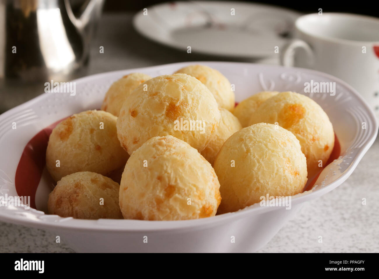 Una semplice colazione brasiliana impostazione, con caffè e pane di formaggio (noto anche come Pão de Queijo), una combinazione di comune in Brasile. Foto Stock