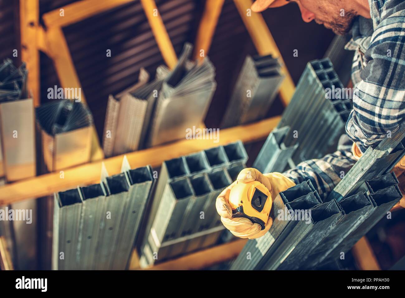 Metallo telai di muretti a secco su rack all'interno di edificio Forniture Store. Imprenditore caucasico cercando materiali di destra. Foto Stock