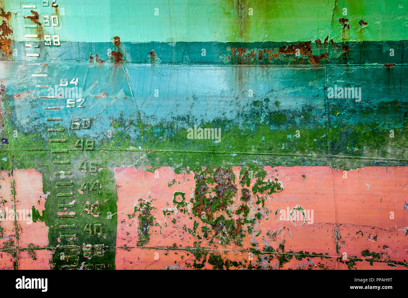 Vecchio e stagionato shiphull con strati di vernice in colori diversi, macchie di ruggine, giunti di saldatura e progetto di marchi Foto Stock