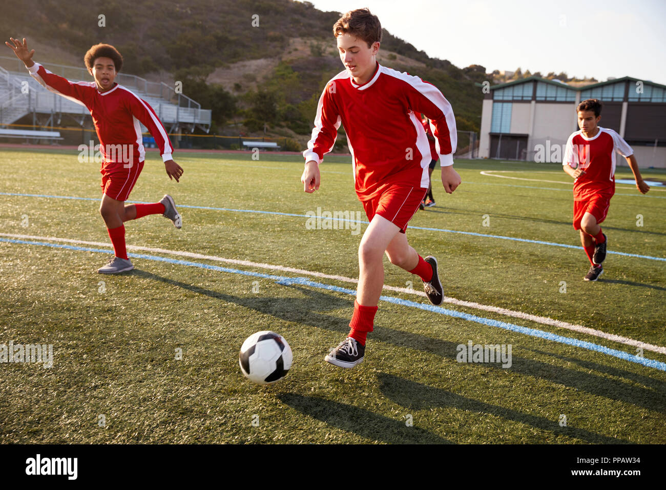Gruppo dei maschi di alta scuola gli studenti giocando in squadra di calcio Foto Stock