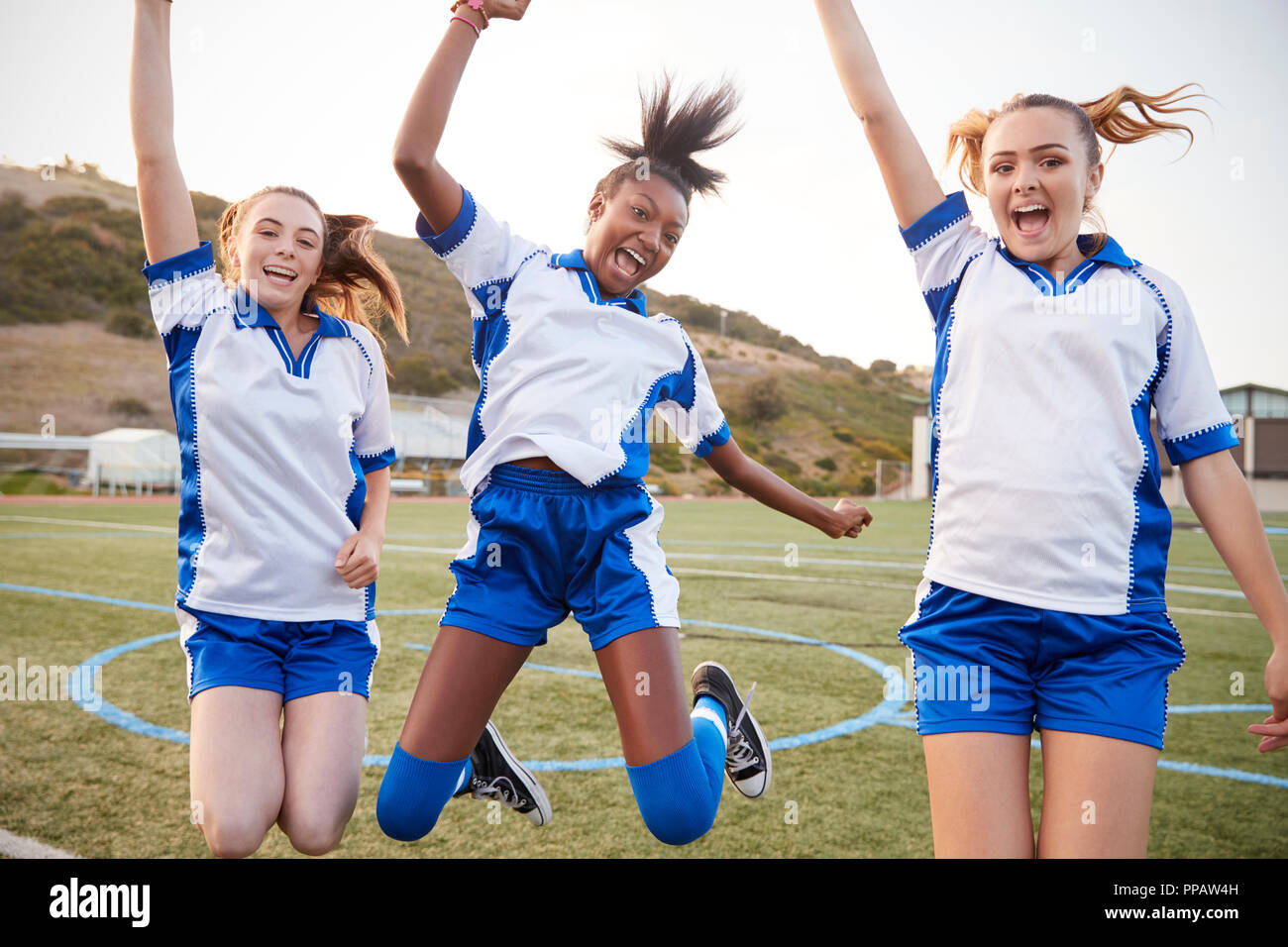 Celebrare la femmina di alta scuola gli studenti giocando in squadra di calcio Foto Stock