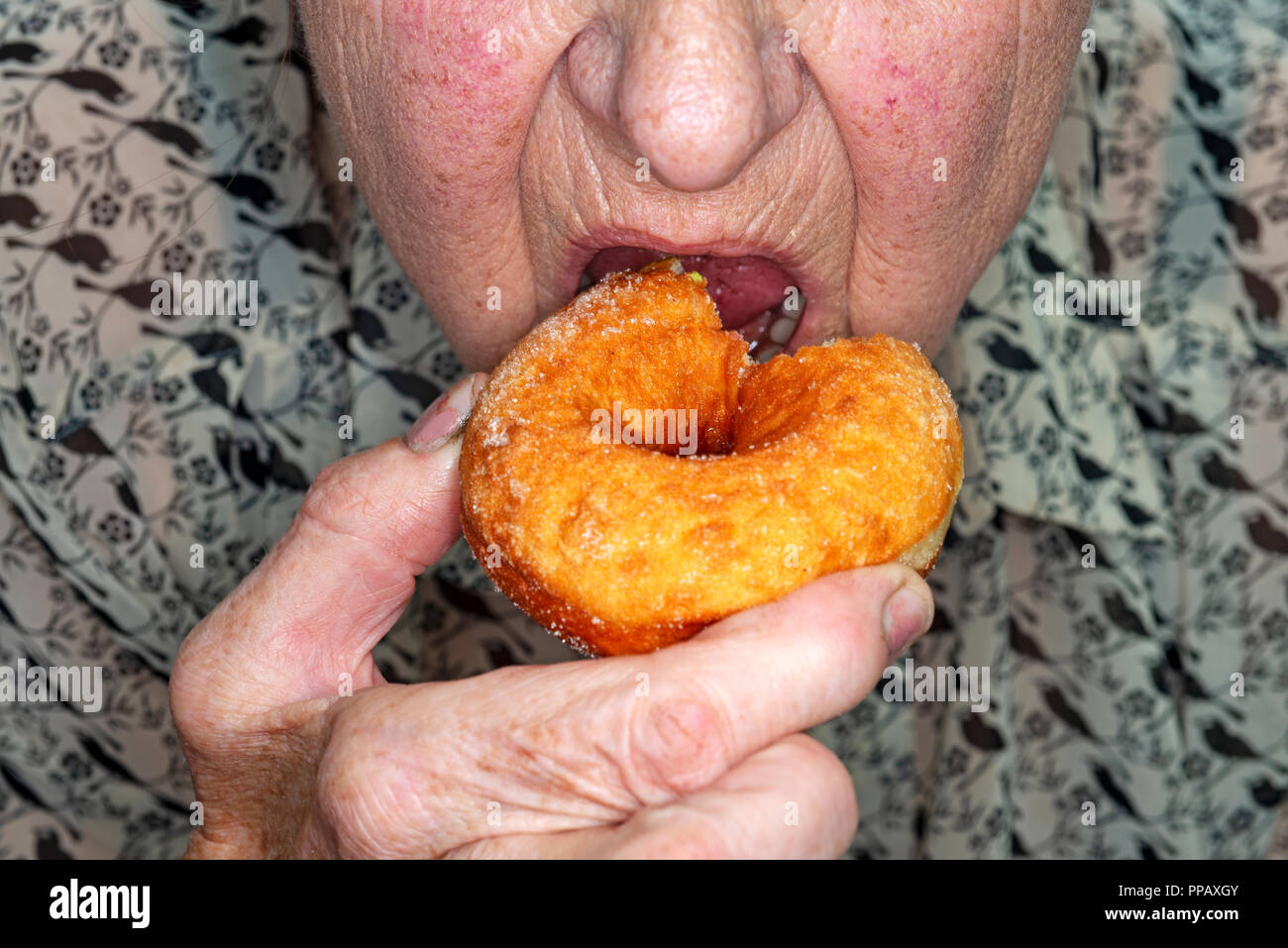 Donna di mangiare una ciambella Foto Stock