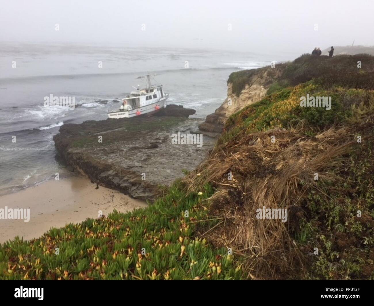 Il 56-piede commerciale nave da pesca, Pacifico Ricerca, è raffigurato sulle rocce vicino a Natural Bridges State Beach, California, e il agosto 12, 2018 dopo l'arenamento domenica mattina presto. Il capitano della nave e il suo cane erano sulla nave quando è collegato a terra, ma non erano in grado di andare a piedi a terra durante la bassa marea con assenza di lesioni. Foto Stock