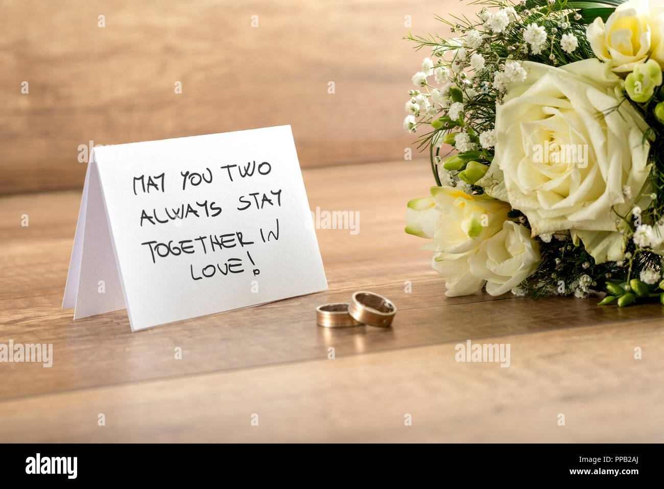 Close up Wedding Greeting Card con voi due sempre stare insieme nel messaggio di amore, bouquet di freschi Fiori bianchi e una coppia di anelli sulla parte superiore di un W Foto Stock