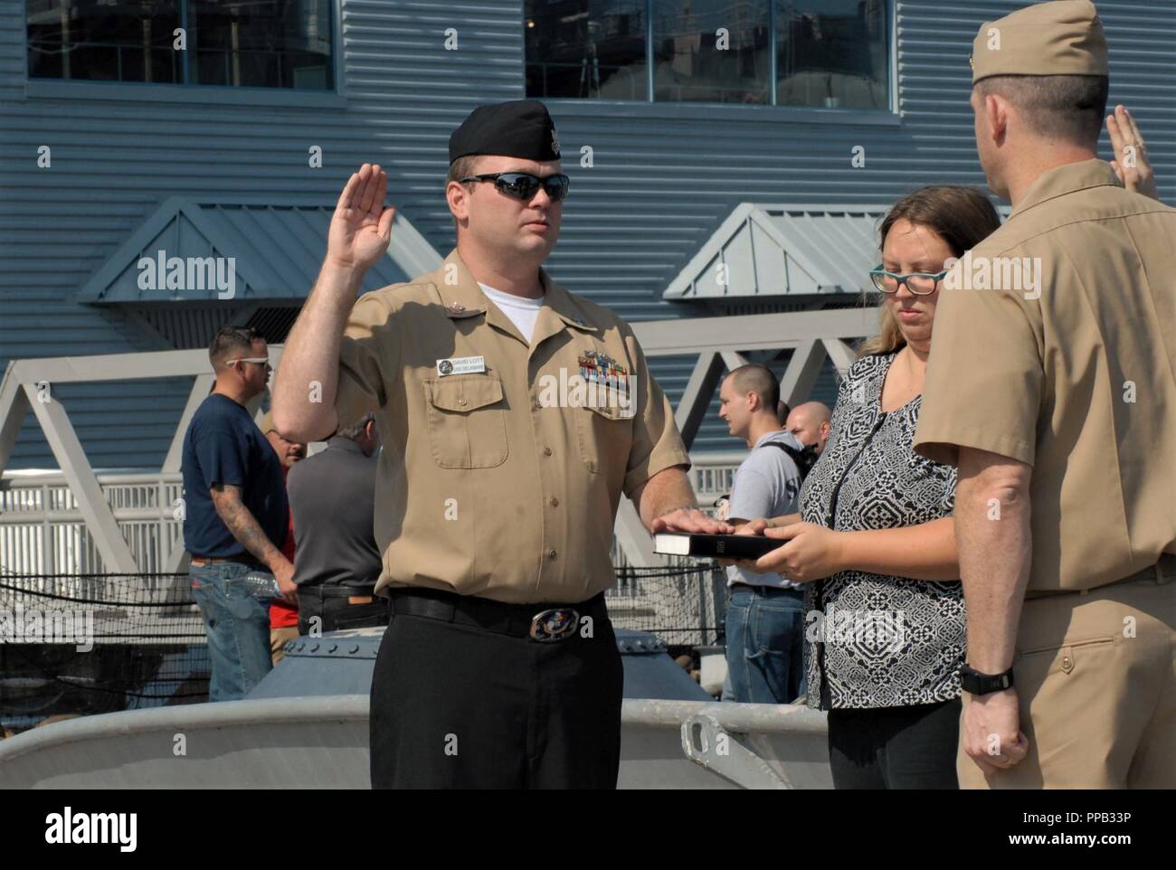 CSS1(SS) David Lott, dall'USS Delaware (SSN-791) re-arruolato a bordo della USS Wisconsin (BB-64) nella parte anteriore dei membri del suo comando e membri della famiglia. La USS Wisconsin è una corazzata Iowa-Class ormeggiata permanentemente accanto all'Hampton Roads Museo Navale in Downtown Norfolk, Virginia. Il museo ospita le cerimonie militari a bordo della nave e le sue gallerie gratuitamente per i comandi di zona. Foto Stock