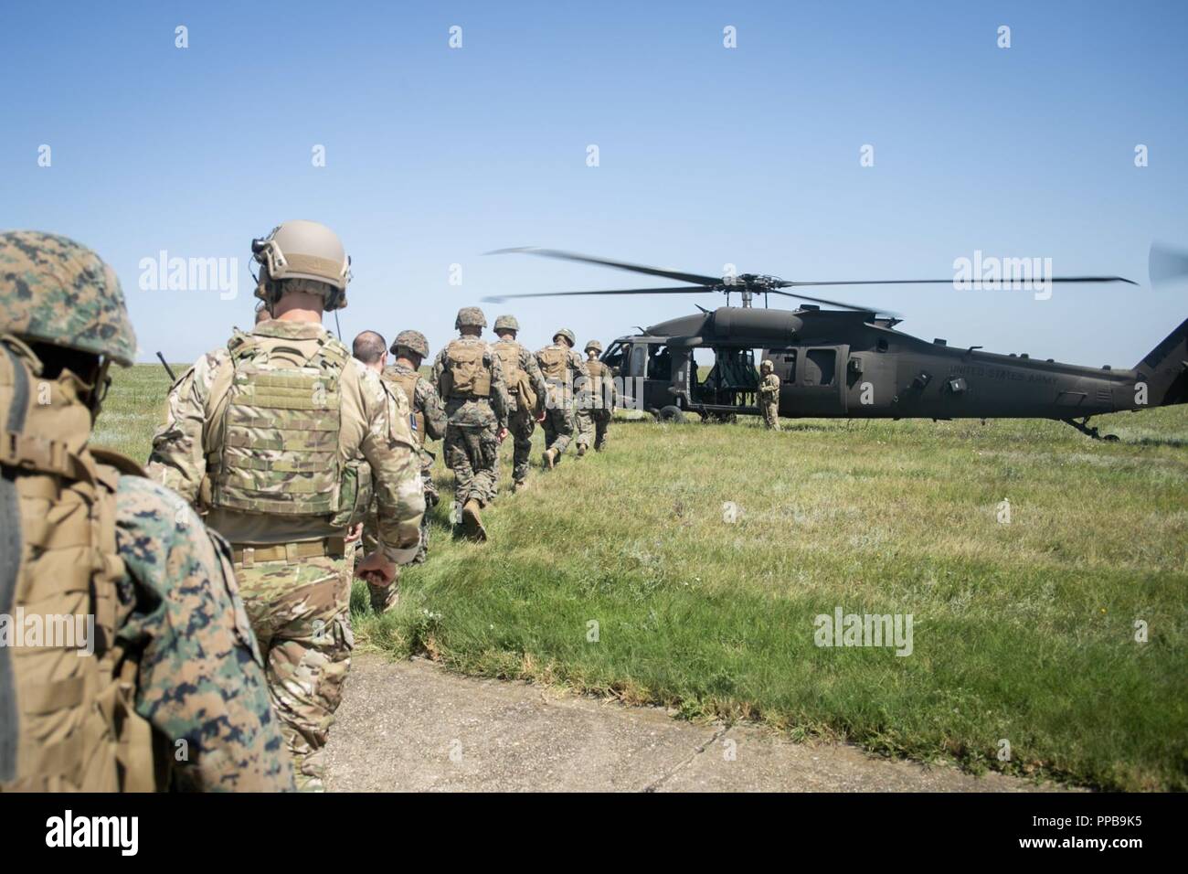 Stati Uniti Marines con il Mar Nero La forza di rotazione 18.1 e British Royal Air Force di personale medico con British 135Expeditionary Air Wing bordo un U.S. Esercito UH-60 Black Hawk elicottero durante una evacuazione medica (MEDEVAC) trapano a Mihail Kogalniceanu Air Base, Romania, Agosto 16, 2018. La formazione simulato le MEDEVAC di figurativamente feriti Marines e civili, la convalida combinati, joint-integrated procedure mediche in caso di un incidente di massa incidente. Foto Stock