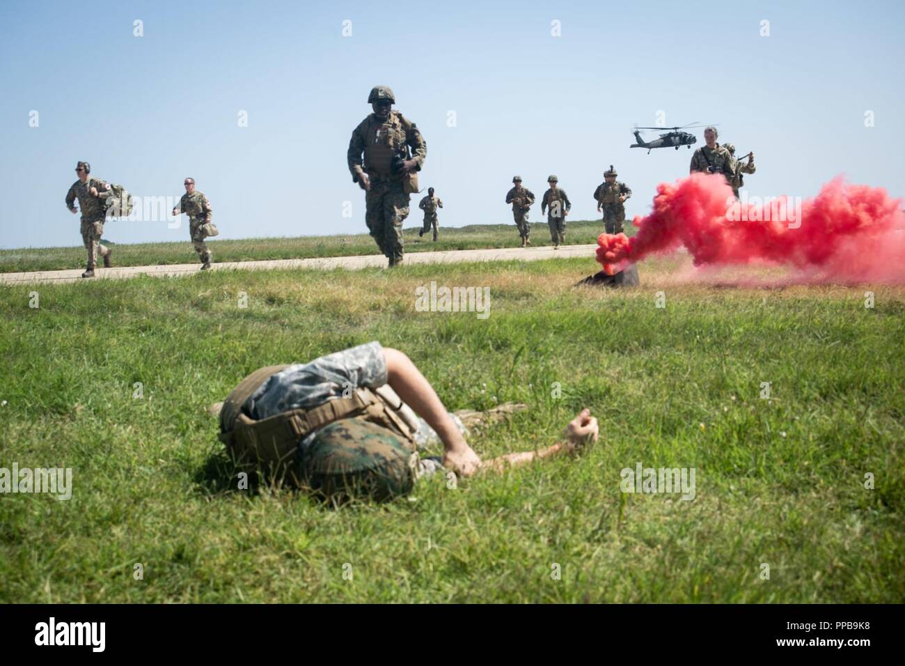 Stati Uniti Navy corpsmen con il Mar Nero La forza di rotazione 18.1 e British Royal Air Force di personale medico con British 135Expeditionary Air Wing muoversi per aiutare figurativamente feriti Marines e civili dopo che arrivano via U.S. Esercito UH-60 Black Hawk elicottero durante una evacuazione medica (MEDEVAC) trapano a Mihail Kogalniceanu Air Base, Romania, Agosto 16, 2018. La formazione simulato le MEDEVAC di figurativamente feriti Marines e civili, la convalida combinati, joint-integrated procedure mediche in caso di un incidente di massa incidente. Foto Stock