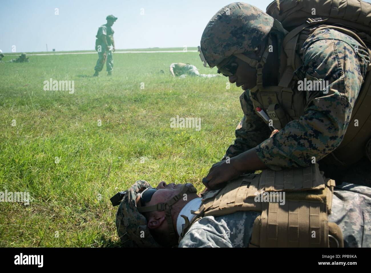 Un U.S. Navy corpsman con il Mar Nero La forza di rotazione 18.1 triages un figurativamente-Marine feriti durante una evacuazione medica (MEDEVAC) trapano a Mihail Kogalniceanu Air Base, Romania, Agosto 16, 2018. La formazione simulato le MEDEVAC di figurativamente feriti Marines e civili, la convalida combinati, joint-integrated procedure mediche in caso di un incidente di massa incidente. Foto Stock