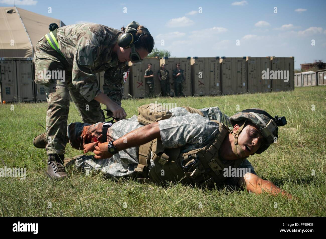 Un British Royal Air Force medic con British135th Expeditionary Air Wing applica un laccio emostatico su un figurativamente feriti Marine con il Mar Nero La forza di rotazione 18.1 durante una evacuazione medica (MEDEVAC) trapano a Mihail Kogalniceanu Air Base, Romania, Agosto 16, 2018. La formazione simulato le MEDEVAC di figurativamente feriti Marines e civili, la convalida combinati, joint-integrated procedure mediche in caso di un incidente di massa incidente. Foto Stock