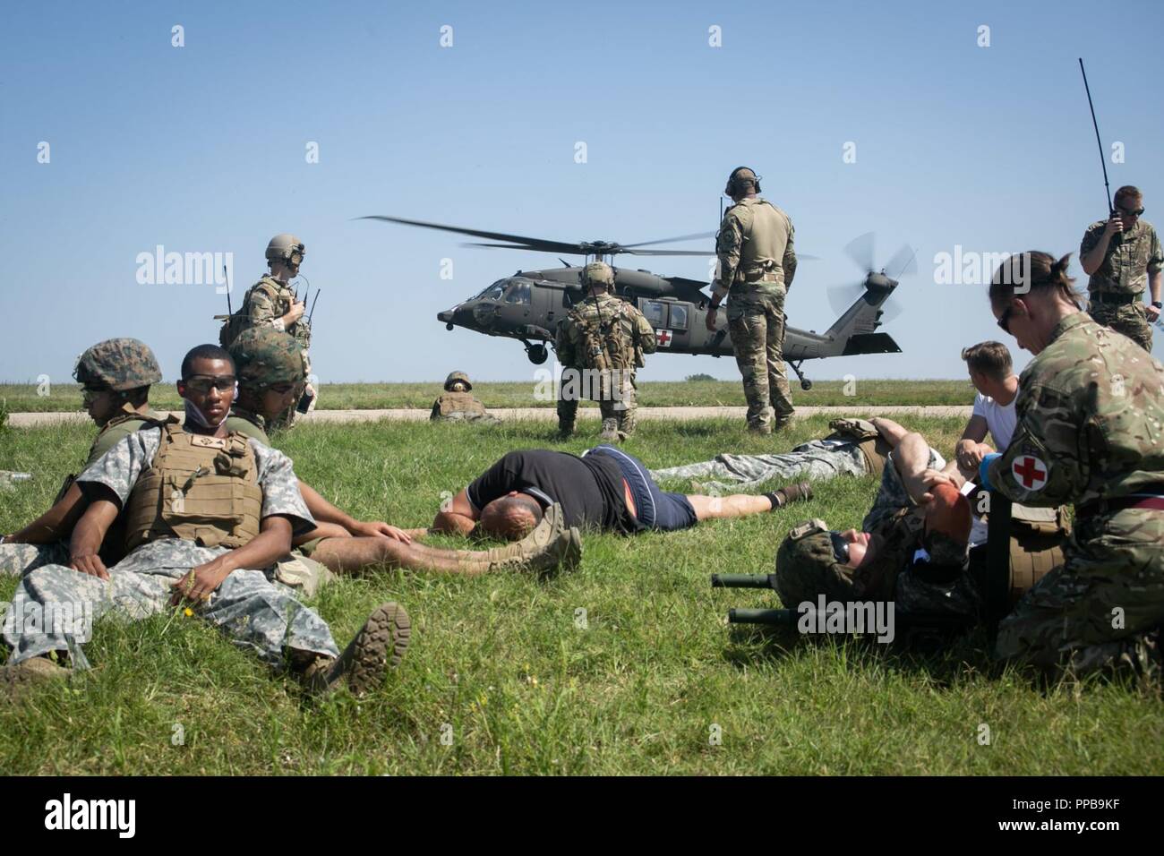 British Royal Air Force di personale medico con British 135Expeditionary Air Wing preparare per spostare figurativamente-feriti fanti di marina con il Mar Nero La forza di rotazione 18.1 a U.S. Esercito HH-60 Black Hawk elicottero durante una evacuazione medica (MEDEVAC) trapano a Mihail Kogalniceanu Air Base, Romania, Agosto 16, 2018. La formazione simulato le MEDEVAC di figurativamente feriti Marines e civili, la convalida combinati, joint-integrated procedure mediche in caso di un incidente di massa incidente. Foto Stock