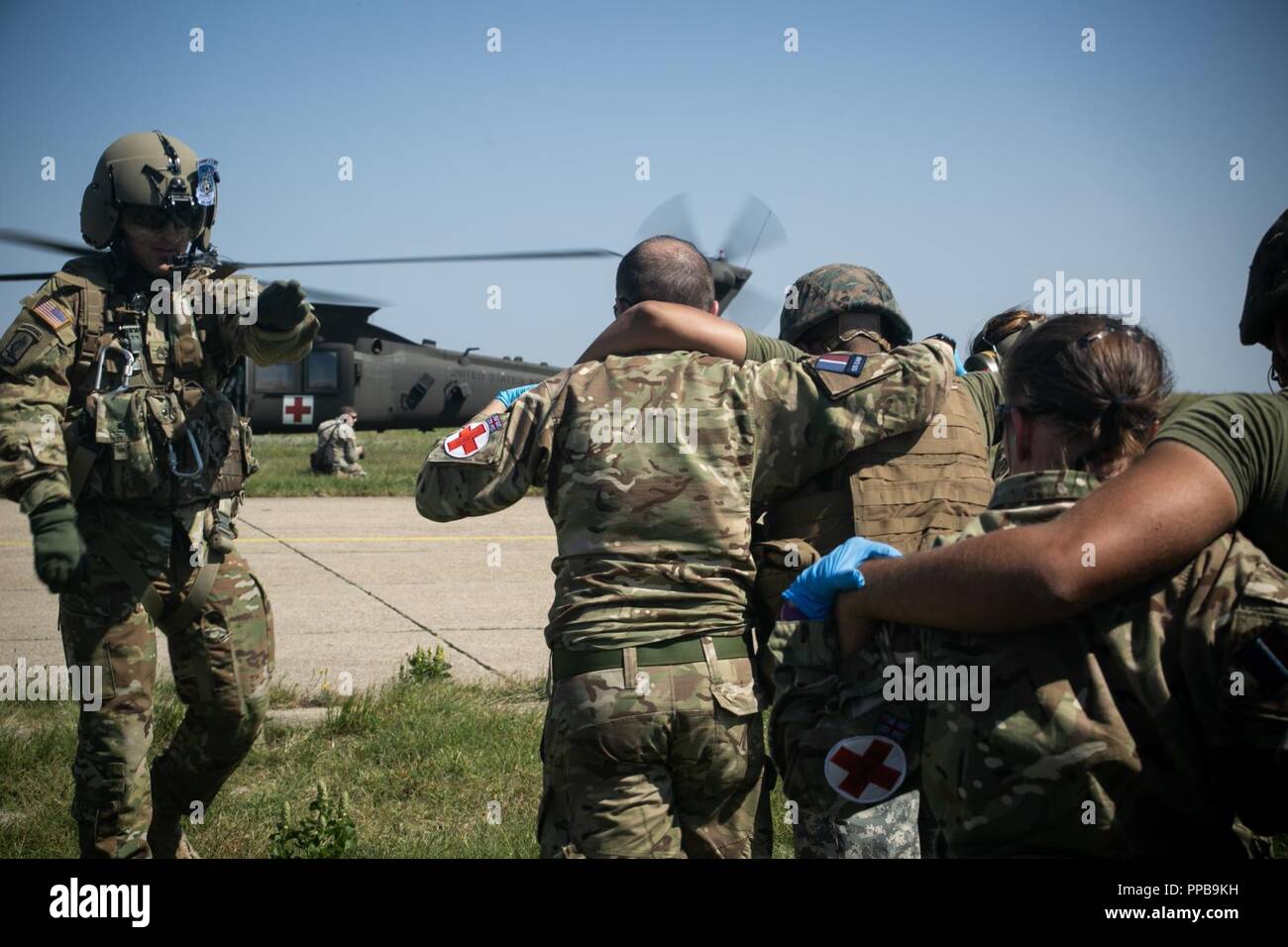 Royal Air Force britannica personale medico con il British 135Expeditionary Air Wing evacuare un figurativamente feriti Marine con il Mar Nero La forza di rotazione 18.1 a U.S. Esercito HH-60 Black Hawk elicottero durante una evacuazione medica (MEDEVAC) trapano a Mihail Kogalniceanu Air Base, Romania, Agosto 16, 2018. La formazione simulato le MEDEVAC di figurativamente feriti Marines e civili, la convalida combinati, joint-integrated procedure mediche in caso di un incidente di massa incidente. Foto Stock
