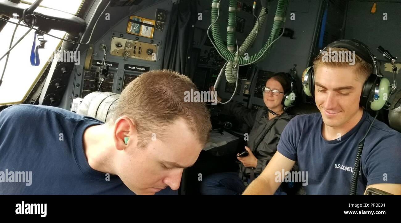 Stazione aria Barbieri punto equipaggio membri Petty Officer di terza classe Rob Miller, Sottufficiali 2rd Paden Classe di canna e sottufficiali di 2a classe di Kate Sonagere condurre controlli di manutenzione su un HC-130 Hercules aeromobili a Hilo Aeroporto Internazionale, Hawaii, Agosto 24, 2018. La Hercules era in Hilo per attendere il multitasking in risposta alla corsia di uragano. Foto Stock