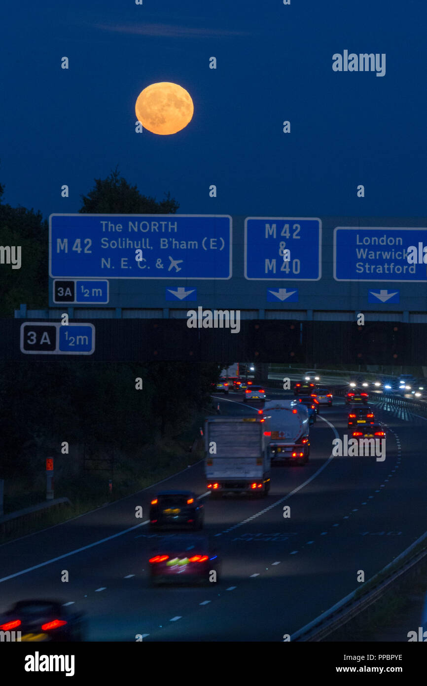 Birmingham, Regno Unito. 24 Settembre, 2018. L'Harvest Moon sorge oltre la trafficata autostrada M42 appena a sud di Birmingham, West Midlands, Regno Unito. Peter Lopeman/Alamy Live News. Foto Stock