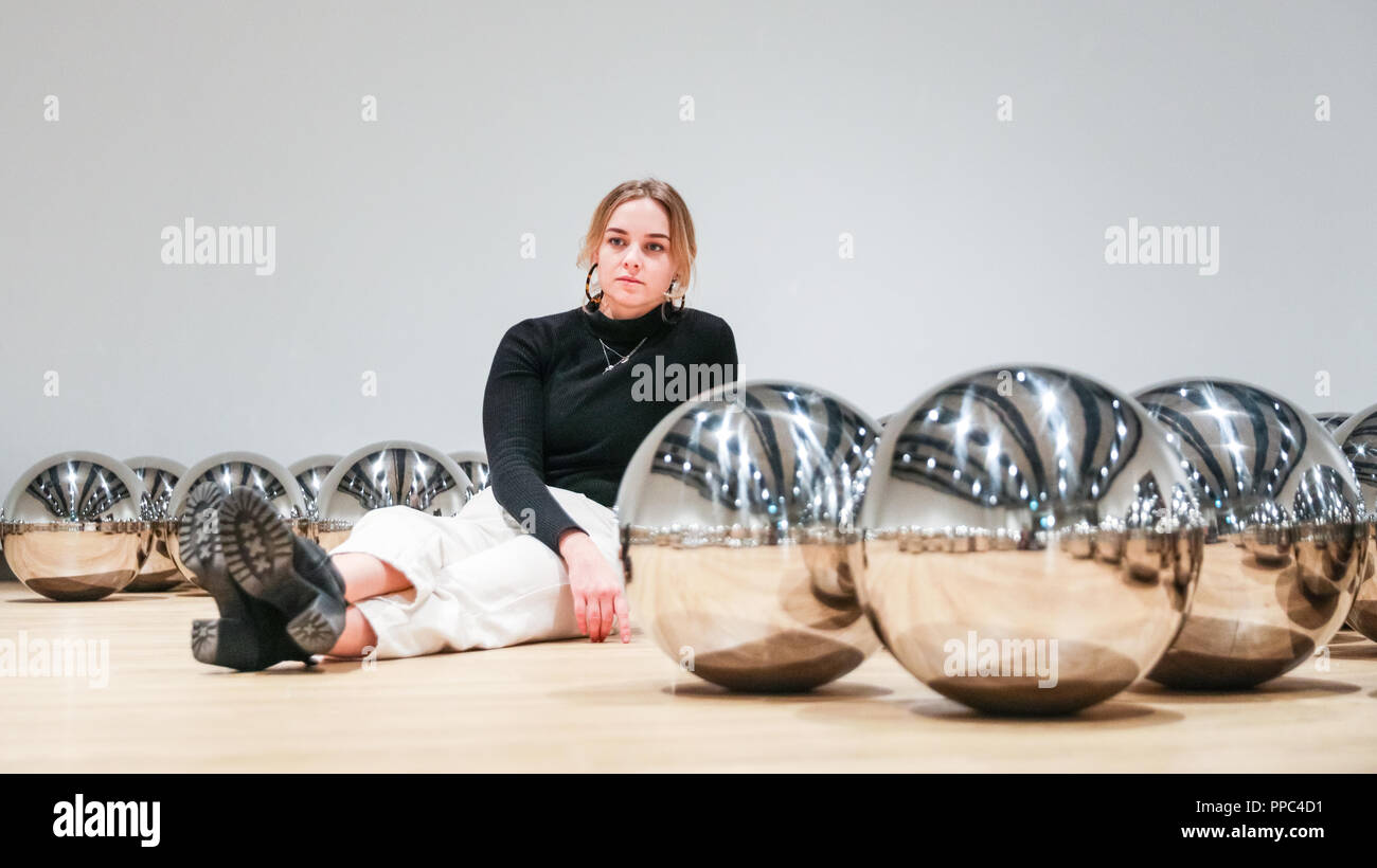 Londra, UK, 25 settembre 2018. Un assistente di galleria pone di Yayoi Kusama del giardino di Narciso con centinaia di sfere in acciaio. Hayward Gallery è di nuovo grande spazio espositivo Shifters dispone di opere d'arte da 20 importanti artisti internazionali che interrompono il visitatore il senso di spazio e di alterare la loro percezione dei loro dintorni. La mostra viene eseguito 26 settembre - 6 gennaio. Credito: Imageplotter News e sport/Alamy Live News Foto Stock