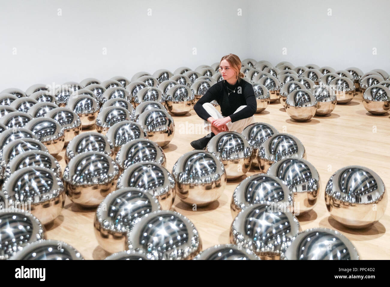 Londra, UK, 25 settembre 2018. Un assistente di galleria pone di Yayoi Kusama del giardino di Narciso con centinaia di sfere in acciaio. Hayward Gallery è di nuovo grande spazio espositivo Shifters dispone di opere d'arte da 20 importanti artisti internazionali che interrompono il visitatore il senso di spazio e di alterare la loro percezione dei loro dintorni. La mostra viene eseguito 26 settembre - 6 gennaio. Credito: Imageplotter News e sport/Alamy Live News Foto Stock