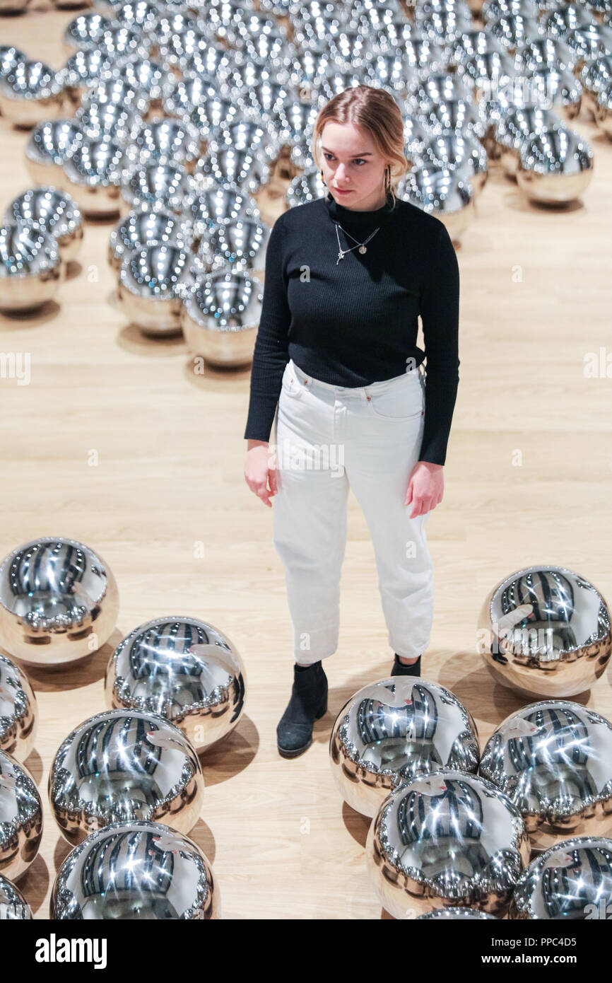 Londra, UK, 25 settembre 2018. Un assistente di galleria pone di Yayoi Kusama del giardino di Narciso con centinaia di sfere in acciaio. Hayward Gallery è di nuovo grande spazio espositivo Shifters dispone di opere d'arte da 20 importanti artisti internazionali che interrompono il visitatore il senso di spazio e di alterare la loro percezione dei loro dintorni. La mostra viene eseguito 26 settembre - 6 gennaio. Credito: Imageplotter News e sport/Alamy Live News Foto Stock