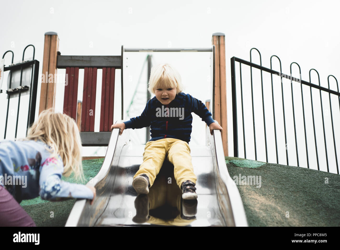 Ragazzino sulla slitta nel parco giochi Foto Stock