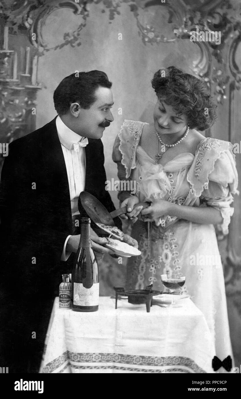 Coppie, flirt, donna ha cucinato per il suo amante e lo serve il cibo, 1910s, Germania Foto Stock