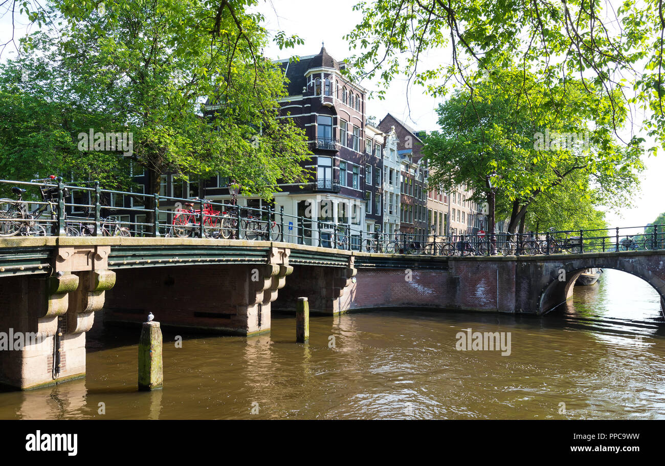 Bella vista dei canali di Amsterdam con il ponte e tipiche case olandese nei Paesi Bassi. Foto Stock