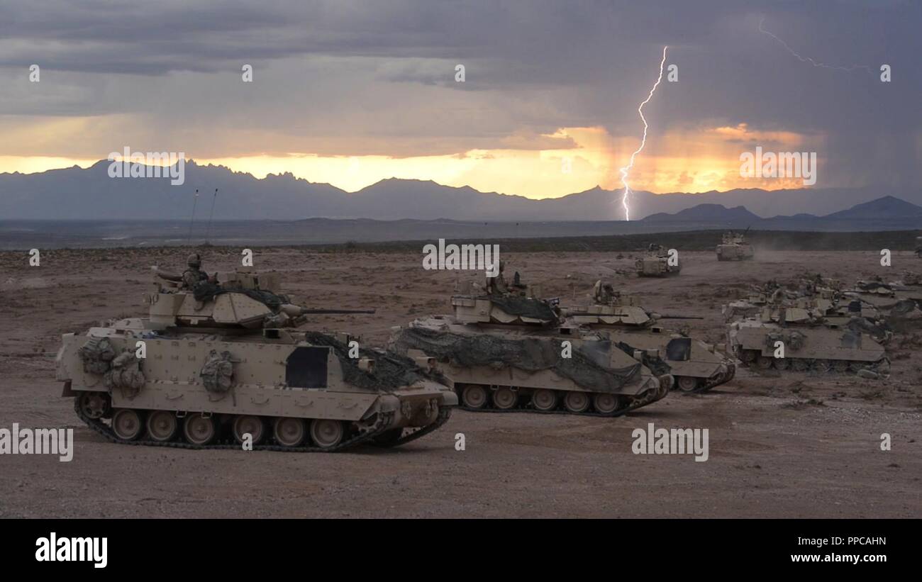 Il fulmine colpisce come Bradley veicoli da combattimento da 1-150th reggimento di cavalleria del trentesimo Armored Brigade Combat Team preparano per sparare missili TOW durante un combinato di armi fuoco vivo Esercizio (CALFEX) a Fort Bliss in Texas il 16 agosto 2018. Questo CALFEX è parte dell'esercito Guardia Nazionale esportabile di combattere la capacità di formazione (XCTC) programma, una brigata strumentato campo esercizio di formazione destinato a certificare plotone proficiency in coordinamento con la prima armata. Foto Stock