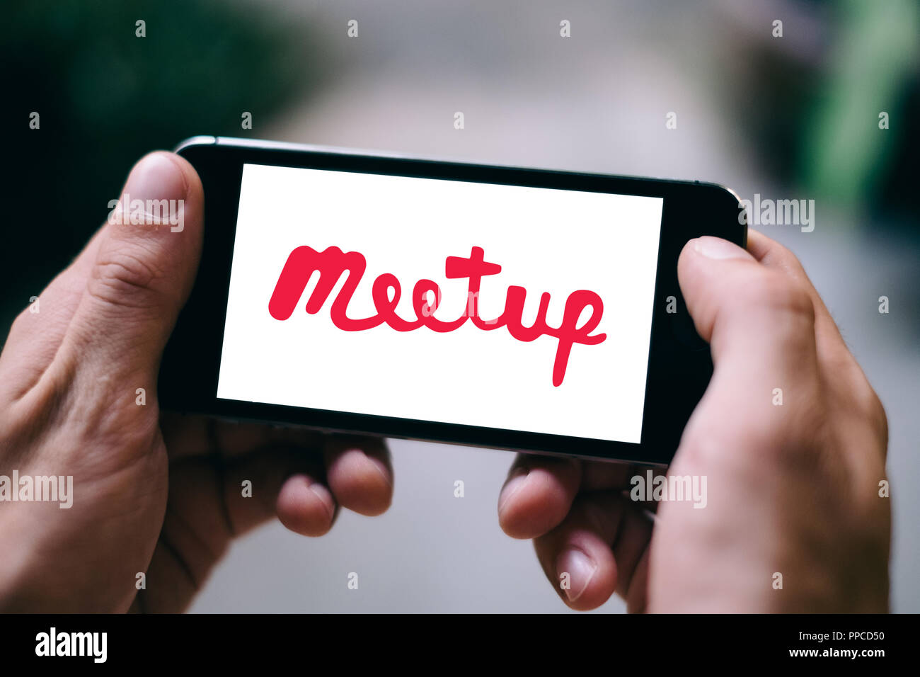 Primo piano della schermata dello smartphone con il logo di Meetup e l'icona Foto Stock