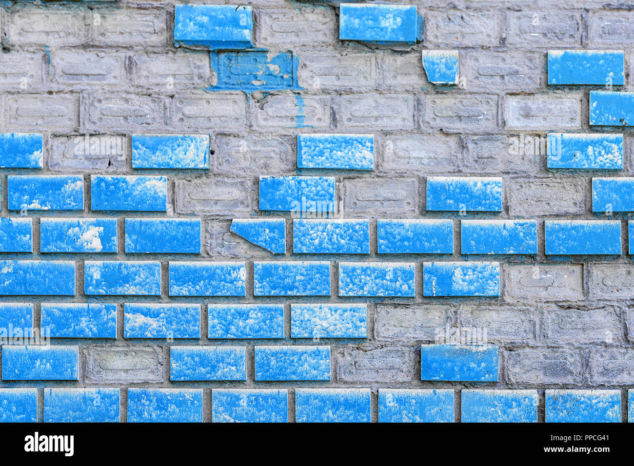 Vecchio weathered blue dipinto di un muro di mattoni con elementi mancanti. Età compresa tra superficie del blocco con parti cadere. Calcestruzzo outdor grunge background urbano Foto Stock