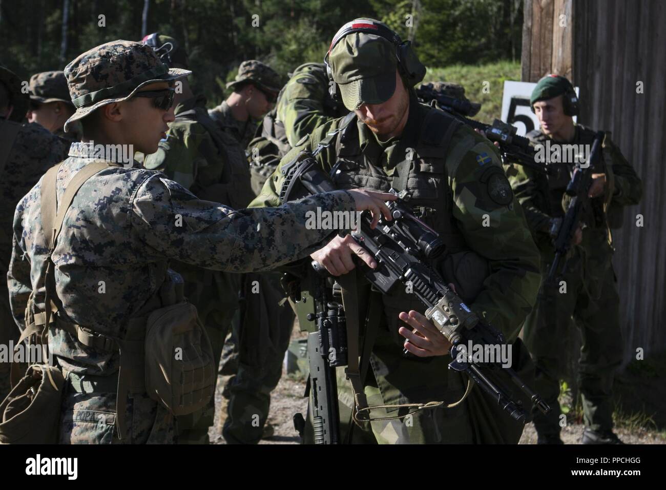 Stati Uniti Marines con Marine Force-Europe rotazionale 18.1 condurre un cross-training gamma durante l'esercizio arcipelago si sforzano con costiere svedesi Rangers del 1° Reggimento marini a bordo di Berga Base Navale, Harsfjarden, Svezia, 22 Agosto, 2018. Esercizio Arcipelago Endeavour è un sistema integrato di formazione sul campo di esercizio che aumenta la capacità operativa e migliora la collaborazione strategica tra Stati Uniti Marines e le forze svedesi. Foto Stock