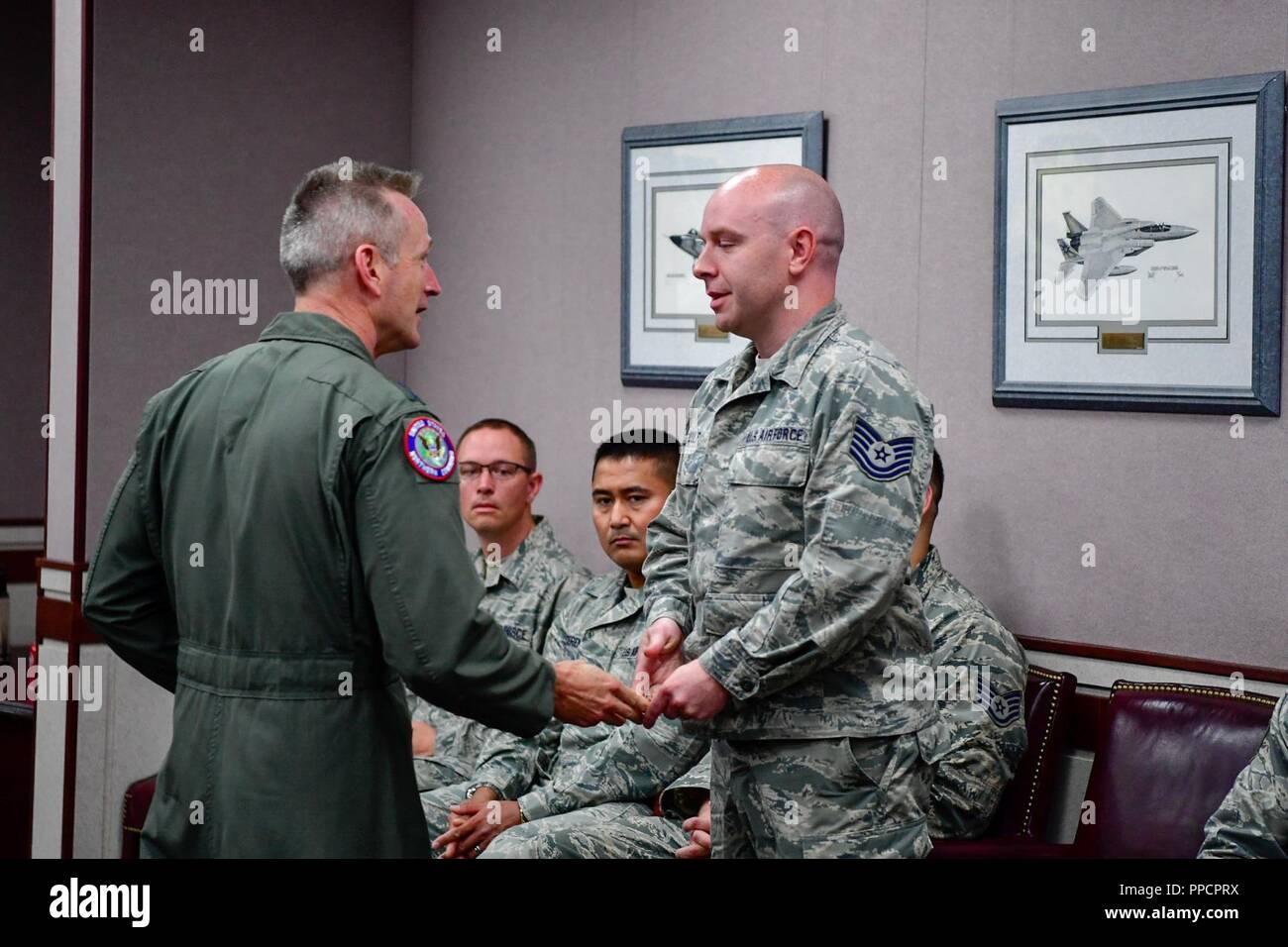 Gen. Terrence O'Shaughnessy, il NORAD e USNORTHCOM commander, riconosce Tech. Sgt. Brian Kulp, 225th Air Defense Squadron armi direttore con un comandante di una moneta per il ruolo fondamentale che ha svolto durante il mese di agosto 10, 2018 F-15 fighter intercettare dell'orizzonte rubato Bombardier Q400 gli aeromobili fuori dell'Aeroporto Internazionale di SeaTac. O'Shaughnessy visitato le borre 23 agosto al fine di raccomandare le operazioni di mazzette di equipaggio per il loro esperto di comando e di controllo della 142th Fighter Wing's F-15 intercettare degli aeromobili rubati. Foto Stock